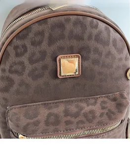 Close-up of leopard print suede shoulder bag featuring gold hardware and metallic logo