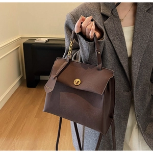 Détail du sac à main rétro en cuir marron avec chaîne dorée et fermoir pivotant