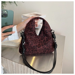 Close-up of leopard print crossbody bag with faux suede texture and rope strap detail
