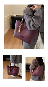 Detail view of burgundy tote bag with beaded tassel and adjustable shoulder strap