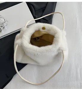 Detail view of large white plush tote bag showing gold magnetic closure and inner lining