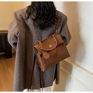 Détail d'un sac à main vintage en cuir marron foncé avec fermoir rotatif doré élégant