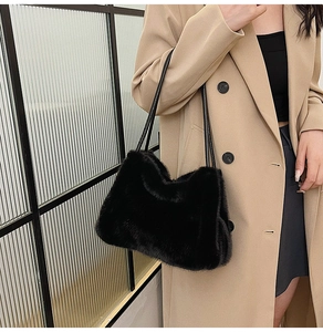Close-up of black faux fur shoulder bag with soft plush texture and slim straps