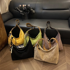Detail view of five assorted color hobo bags with leather straps and beaded charms