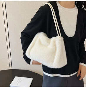 Detailed view of soft white faux fur shoulder bag with thin leather straps for autumn winter