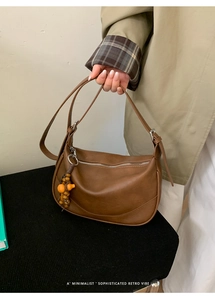 Detail of caramel brown moon bag with vintage wooden beads and matte texture leather strap