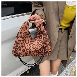 Close-up of leopard print hobo bag with plush texture and slim black shoulder strap