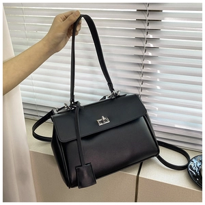 Detail of black leather rectangle bag with silver turn-lock and contrast stitching