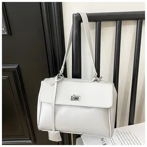 Close-up of a light grey bucket bag with a silver metal turn-lock clasp on a black chair