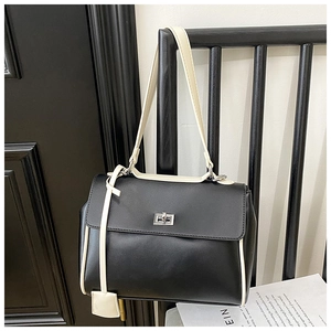 Detail of minimalist black and white bucket bag featuring silver twist lock and trim