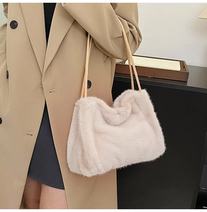 Close-up of beige plush tote bag with soft faux fur texture and slim leather straps