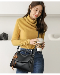Chic black litchi pattern Boston bag with wood bead tassel shown in elegant outdoor setting