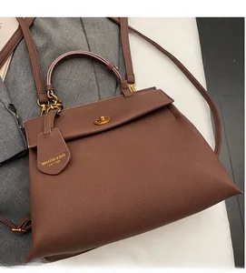 Détail du sac à main marron à motif litchi avec fermoir doré et étiquette en cuir