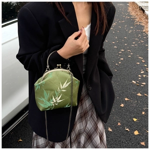 Détail d'un sac à main vert rétro avec motif de bambou et fermoir métallique chic