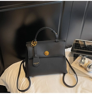 Détail du sac à main en cuir grainé noir avec fermoir doré et accessoire de chaîne