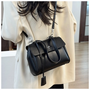 Rear view of model wearing a black minimalist leather crossbody bag with silver hardware
