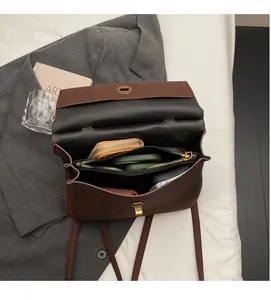Vue intérieure du sac en cuir marron montrant trois compartiments de rangement spacieux