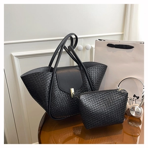 Close-up of black woven leather tote bag with golden lock and small matching pouch