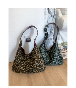 Detail view of leopard print hobo bags with metallic rivet straps and deep red lining
