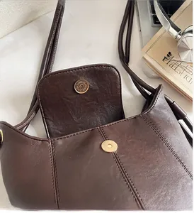Detail of premium brown leather bucket bag with glossy magnetic clasp and fine stitching