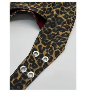 Close-up of leopard print canvas tote strap with silver grommets and red lining