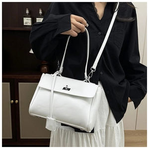 Detail of white PU leather crossbody bag featuring silver twist-lock and charm decor