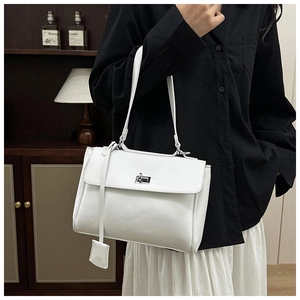 Detail of white leather bucket bag with silver rotating lock and side charm pendant