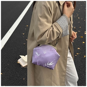 Détail de la pochette de soirée en satin lilas avec motif bambou et fermoir métallique