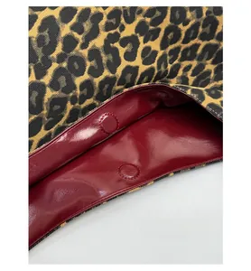 Detail of leopard print tote with dark red patent leather lining and magnetic buckle