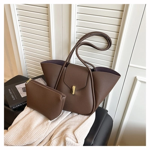 Detailed close-up of dark brown lychee leather tote with gold metal buckle and insert bag