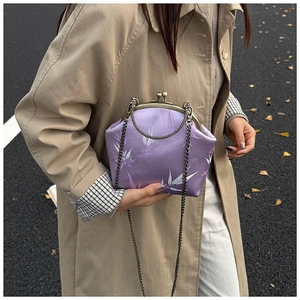 Détail du sac coquille en soie lilas avec imprimé feuilles de bambou et fermoir métal