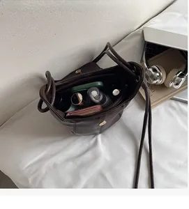 Macro shot of spacious inner bucket bag showing wallet, cosmetics, and phone storage