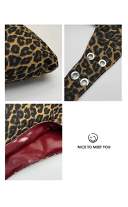 Detail of leopard print canvas bag with red lining, metal eyelets and magnetic closures