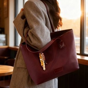 Burgundy faux leather tote bag with beaded charm and large capacity for commuting