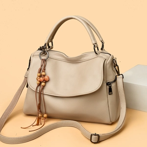 Beige Boston handbag with pebble leather texture and bohemian beaded tassel pendant