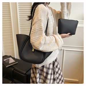 Close-up of black litchi pattern leather tote bag set with metal buckle detail