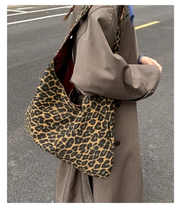 Outdoor street view of a large leopard print tote bag paired with a stylish brown trench coat