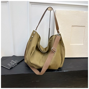 Detail of vintage canvas tote with brown leather strap and silver metal hardware