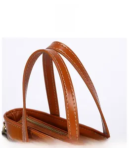 Close-up of precise stitching and reinforced handle on brown crocodile pattern bucket bag