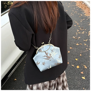 Détail du sac coquille en satin bleu avec motif bambou et bandoulière chaîne