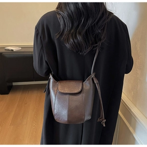 Detail view of a vintage dark brown leather bucket bag on model for scale and fit
