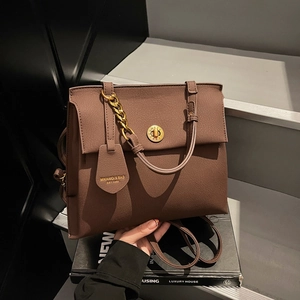 Sac à main vintage en cuir marron texturé avec chaîne dorée et fermoir pivotant
