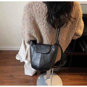 Close-up of black leather bucket bag showing soft texture and stitching details
