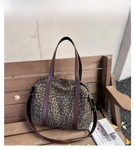 Macro detail of leopard print tote bag texture with brown leather strap and metal hardware