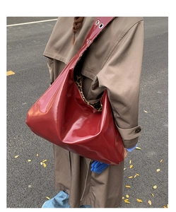 Street style shot of large dark red patent leather tote bag with leopard print lining