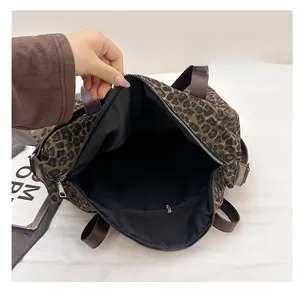 Interior view of leopard print tote bag showing black fabric lining and zippered inner pocket
