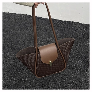 Detail of woven brown leather tote bag with gold buckle and smooth leather flap