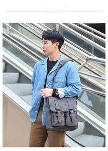 Close-up of retro dark gray messenger bag with double buckles on outdoor stairs