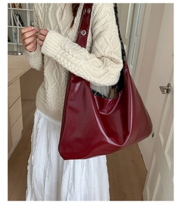 Detail view of burgundy patent leather tote bag with wide strap and leopard lining