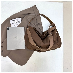 Detail shot of heavy brown canvas tote bag with adjustable wide strap and silver buckle